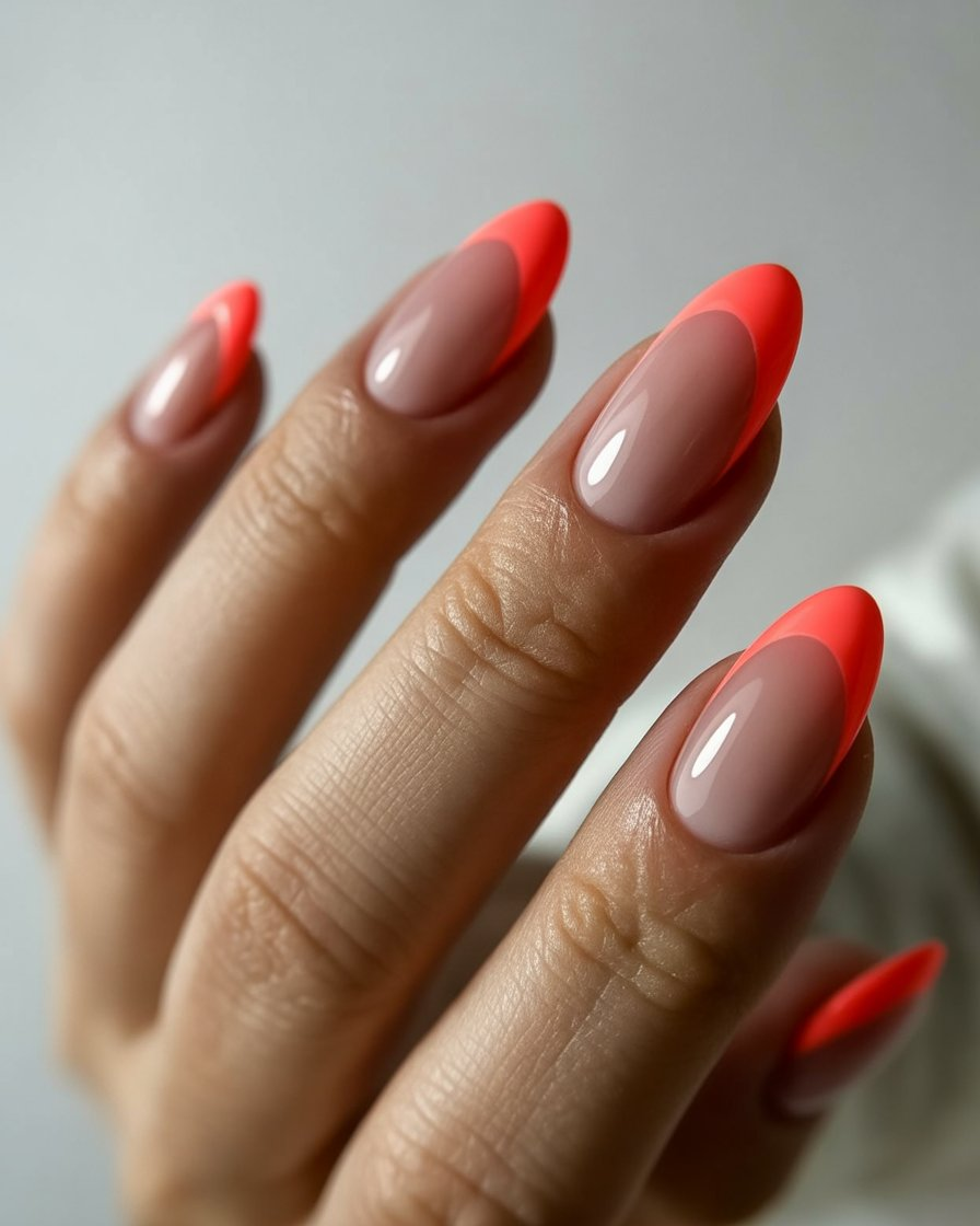 Coral French tips on a nude base for a sleek and modern look.