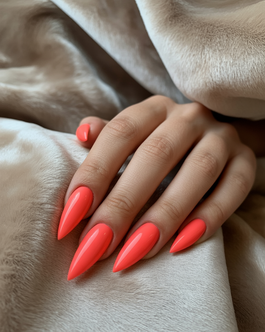Bold coral stiletto nails for a dramatic and fierce look.