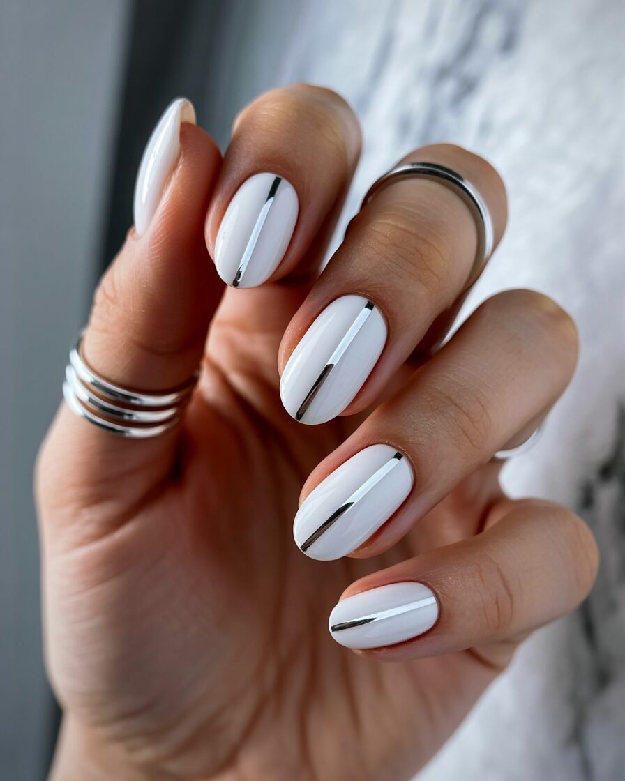 Glossy white nails with silver stripes, perfect for a modern, minimalist bridal look.