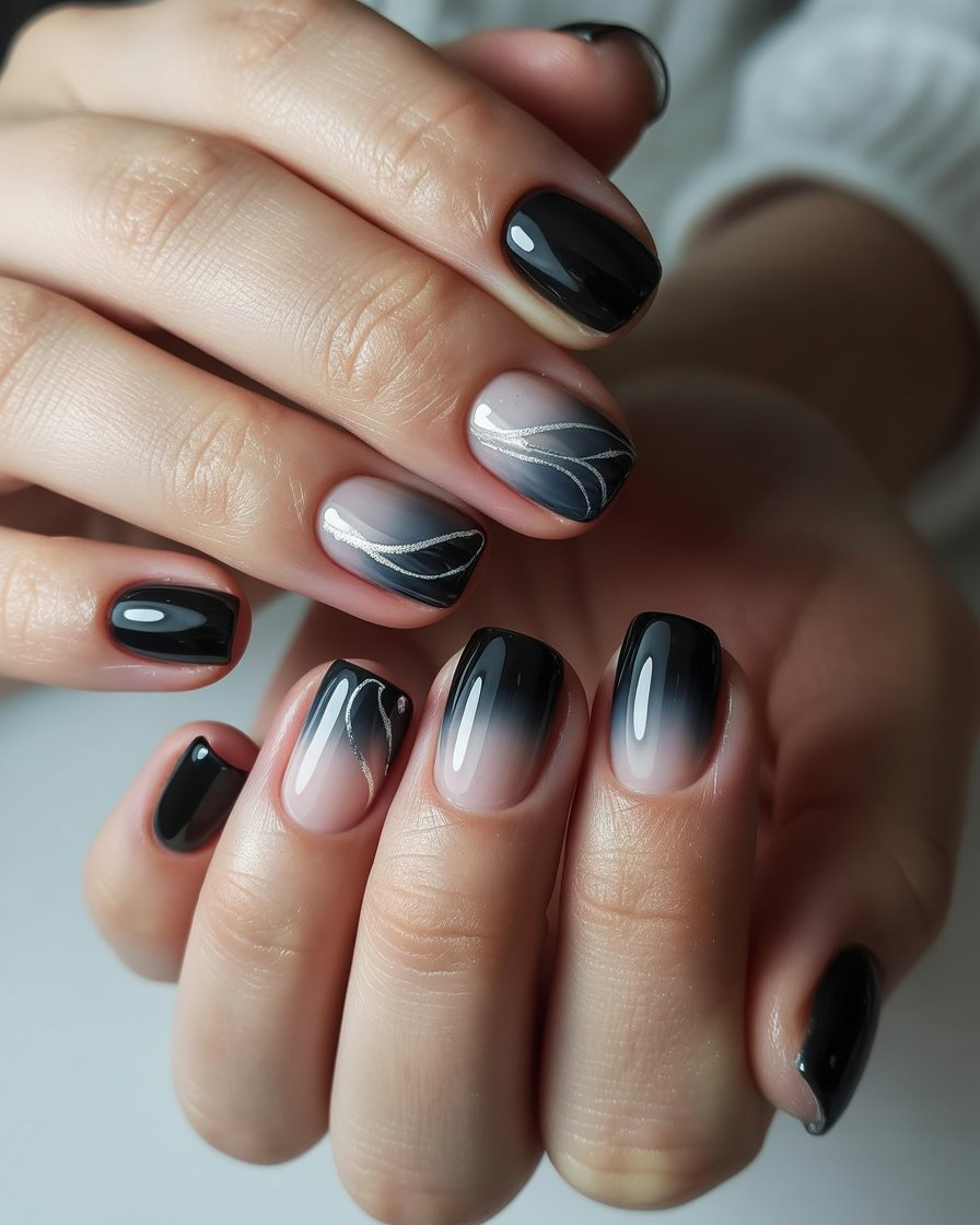 Black ombre nails featuring delicate silver swirl designs, creating a stylish and versatile gradient manicure with a glossy finish.
