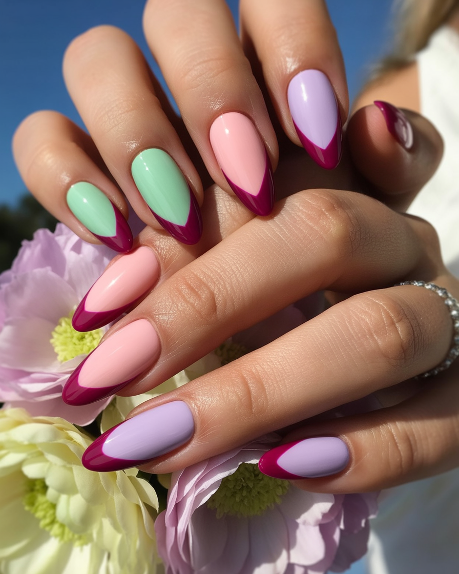 Pastel-colored nails with burgundy chevron patterns alternating across the hand.