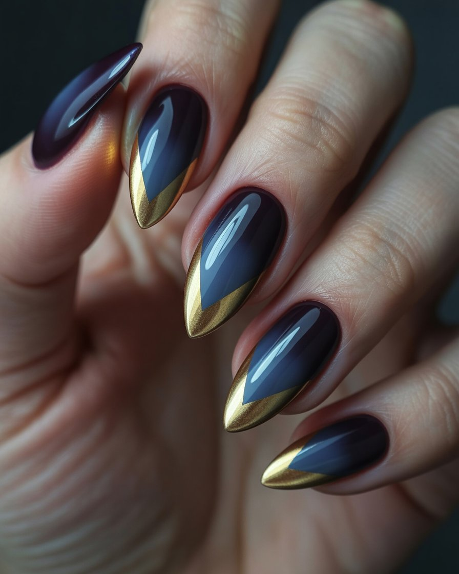 Nails with V-shaped gold foil tips over navy-black ombré base