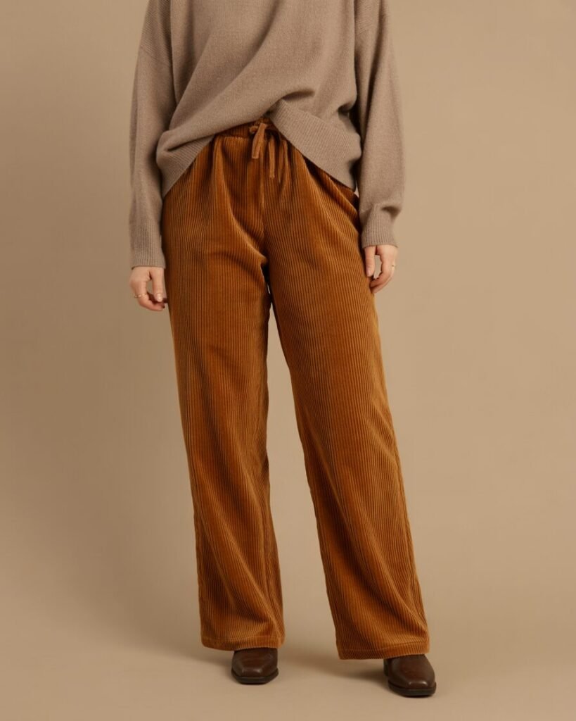 A mid-size woman in corduroy pants and a cozy sweater.